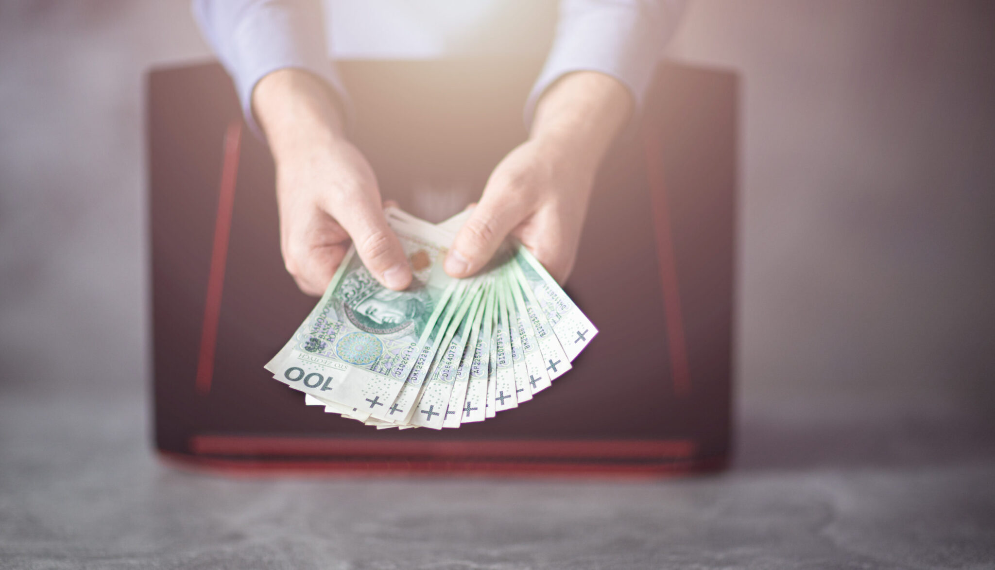 pożyczka. Polskie pieniądze trzymane przez bankowca w ręce., W ogólnopolskim badaniu „Sytuacja NGO-sów w czasie pandemii” ponad pół tys. organizacji wskazało najpoważniejsze obecnie zagrożenia dla swojej działalności. Kluczowym problemem, zwłaszcza w największych aglomeracjach, są kłopoty w zdobywaniu bieżących funduszy. Druga trudność to biurokracja administracji publicznej. To z kolei przeważnie występuje na wsiach i w kilkunastotysięcznych miastach. Spore niepokoje budzi też m.in. konkurencja, nadmierna kontrola organów państwa i konieczność wypłaty stałych wynagrodzeń pieniężnych. Badanie, przeprowadzone dla portalu zbiórkowego Szczytny-Cel.pl wśród 266 fundacji i 255 stowarzyszeń, wykazało, z czym najbardziej zmagają się organizacje pozarządowe w dobie pandemii. Podmioty mogły wskazać w ankiecie 5 głównych problemów. I najwięcej z nich, tj. 42,6%, podało trudności w zdobywaniu bieżących funduszy. – Pozyskiwanie środków na bieżące potrzeby zawsze było największym wyzwaniem dla organizacji pozarządowych. Natomiast pandemia zaostrzyła stale występujące w tym sektorze obawy, że nie uda się zdobyć niezbędnych środków do prowadzenia działalności. Mocno wpłynęły na to cięcia budżetowe w samorządach finansujących podmioty pożytku publicznego – komentuje dr Justyna Kościńska, adiunkt w Centrum Europejskich Studiów Regionalnych i Lokalnych na Uniwersytecie Warszawskim oraz członkini Stowarzyszenia „Miasto Jest Nasze”. Jak wykazał raport, trudności ze zdobywaniem bieżących funduszy przeważnie deklarują organizacje z miast liczących co najmniej 500 tys. mieszkańców – 55,1%. Problem ten głównie dotyka podmioty działające na rynku nie dłużej niż 5 lat – 48%, a także istniejące ponad 15 lat – 46,9%. Najczęściej wskazują go stowarzyszenia i fundacje wspierające seniorów – 45,9%, jak również lokalną społeczność – 45,8%. – Wydawałoby się, że duże miasta sprzyjają tego typu działalności, a właśnie tam badani najbardziej się skarżą. Wynika to z tego, że w takich aglomeracjach walczy o fundusze najwięcej stowarzyszeń i fundacji. Najtrudniej mają młode podmioty, które dopiero pracują na zaufanie. Jednak starsze organizacje też nie mają łatwo, bo ich atrakcyjność dla darczyńców z czasem spada – mówi Maciej Kamiński, Prezes Zarządu platformy zbiórkowej Szczytny-Cel.pl. Drugim najczęściej wskazywanym problemem jest biurokracja administracji publicznej – 35,1%. Jak tłumaczy dr Kościńska, reprezentujące ją podmioty działają w zupełnie inny sposób niż organizacje pozarządowe. Mają też odmienne potrzeby i ograniczenia. Dlatego ta bariera zawsze istniała, ale stała się bardziej widoczna w czasie pandemii. I jak wynika z badania, obecnie najczęściej zgłaszają ją najmłodsze organizacje, istniejące nie dłużej niż 5 lat – 44%, na wsiach i w miastach liczących do 19 tys. mieszkańców – 46,2%, na rzecz dzieci i młodzieży – 45,9%, a także dla lokalnej społeczności – 38,5%. – Z moich obserwacji wynika, że podmioty z mniejszym stażem bardziej dostrzegają biurokrację. To oczywiście nie znaczy, że jej nie ma, ale warto zrozumieć specyfikę pracy administracji publicznej i nauczyć się z nią funkcjonować. Oczywiście działając na wsiach i nawet w kilkunastotysięcznych miastach można mieć większe kłopoty natury prawno-administracyjnej, w tym słabszy dostęp do prawników, doradców podatkowych i innych specjalistów – zaznacza Maciej Kamiński. Trzecim zagrożeniem, jakie widzą dla siebie stowarzyszenia i fundacje, jest konkurencja ze strony innych organizacji – 32,6%. Najbardziej obawiają się jej podmioty działające już 11-15 lat – 35,4%, a także istniejące nie dłużej niż 5 lat – 32,8%. Ten problem najczęściej jest wskazywany w miastach mających powyżej 500 tys. mieszkańców – 39,7%. Przeważnie zgłaszają go organizacje zajmujące się sprawami lokalnej społeczności – 36,5%. – W największych polskich miastach rzeczywiście występuje bardzo duża konkurencja wśród organizacji, ponieważ jest ich wiele i wszystkie mocno starają się pozyskać fundusze, zwłaszcza u władz lokalnych. W mniejszych miejscowościach często łatwiej jest się przebić ze swoją inicjatywą, szczególnie działając jako jeden z niewielu tego typu podmiotów na rzecz miejscowej społeczności – stwierdza dr Kościńska. Na czwartym miejscu na liście największych zagrożeń dla organizacji pozarządowych jest nadmierna kontrola organów państwa – 31,9%. Jak podkreśla Maciej Kamiński, w czasie pandemii organy państwowe dużo rzadziej je kontrolowały niż wcześniej. Dlatego ten czynnik ma mniejsze znaczenie niż trzy główne problemy, mocniej związane z walką o przetrwanie na rynku. Natomiast fakt, że taka bariera wciąż jest jedną z czołowych w prowadzeniu działalności dobroczynnej, nie jest dobrą informacją. – Warto pogłębić to badanie, by ustalić, na czym polega nadmierna kontrola. Pojawia się pytanie, czy chodzi o naciski, nękanie, utrudnianie lub wręcz uniemożliwianie działań organizacjom, których cele nie są po drodze organom państwa z powodów ideologicznych czy podzielanych wartości. Myślę tutaj przede wszystkim o podmiotach wspierających uchodźców i wszelkie wykluczane grupy ze względu na jakikolwiek czynnik, np. preferencje seksualne – zwraca uwagę dr hab. Małgorzata Molęda-Zdziech, kierownik Katedry Studiów Politycznych ze Szkoły Głównej Handlowej w Warszawie. Piątym wskazywanym przez badanych obciążeniem jest wypłata stałych wynagrodzeń pieniężnych – 30,7%. Jak zauważa ekspert z platformy zbiórkowej Szczytny-Cel.pl, pandemia najmocniej uwypukliła problemy z płynnością finansową tam, gdzie one już wcześniej istniały. Dlatego jest to postrzegane jako jeden z największych problemów. – Nie każda organizacja zatrudnia pracowników, którym musi płacić pensje. Niemniej podmioty będące pracodawcami borykają się z tym problemem, jeżeli jednocześnie mają kłopoty z pozyskiwaniem funduszy na bieżące działania. Jest to powiązane z najczęściej wskazywaną przez ankietowanych barierą – zauważa dr Justyna Kościńska. Dość długą listę problemów i zagrożeń, z jakimi spotykają się NGO-osy, zamyka brak zainteresowania dziennikarzy ich bieżącymi działaniami – 13,1%. Podobne wyniki mają takie kwestie, jak niekorzystny wizerunek organizacji pozarządowych w mediach i w opinii społeczeństwa – 13,8%, a także trudności w dostępie do lokalu potrzebnego do prowadzenia działalności – 14%. – Działania organizacji pozarządowych najczęściej stają się tematem dla dziennikarzy dopiero, gdy można pokazać coś sensacyjnego. Dlatego warto zwrócić uwagę na konieczność podejmowania działań komunikacyjnych w mediach społecznościowych, które umożliwiają docieranie z przekazem do wybranych grup społecznych i pozyskiwanie ich zaufania. To z kolei konieczne jest przy prowadzeniu akcji fundraisingowych – przekonuje dr Molęda-Zdziech. Natomiast dr Kościńska uważa, że ww. wyniki mogą oznaczać, iż zainteresowanie mediów działaniami organizacji pozarządowych jest wystarczające. Oczywiście warto poprawić sytuację, zwiększając ich popularność w środkach masowego przekazu. – Trudności lokalowe dotyczą zaledwie 14% badanych organizacji. To wskazuje, że obecnie fizyczna przestrzeń coraz częściej nie jest konieczna do podejmowania aktywności. Oczywiście wygląda to różnie w zależności od regionu i pola działania. Niemniej w praktyce znacznie większym problemem bywa utrzymanie personelu, w tym pracowników i wolontariuszy, co znalazło swoje miejsce w połowie ww. listy zagrożeń – podsumowuje ekspertka ze Szkoły Głównej Handlowej w Warszawie. Badanie pt. „Sytuacja NGO-sów w czasie pandemii” zostało przeprowadzone metodą CAWI przez UCE RESEARCH i SYNO Poland dla portalu zbiórkowego Szczytny-Cel.pl. Wzięło w nim udział 521 podmiotów pożytku publicznego z 16 województw. NGO